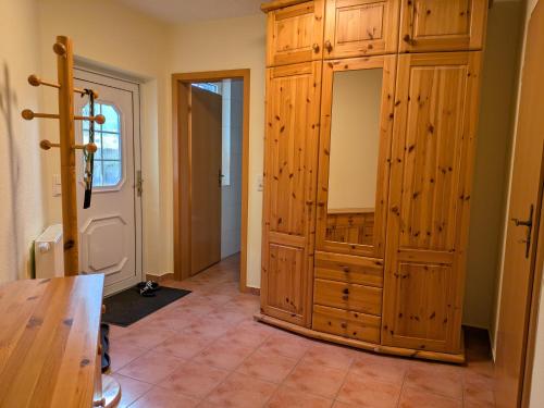 a room with a large wooden cabinet next to a door at Ferienwohnung Holunderweg in Bad Doberan