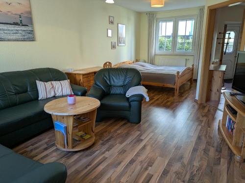 a living room with a couch and a table and a bed at Ferienwohnung Holunderweg in Bad Doberan