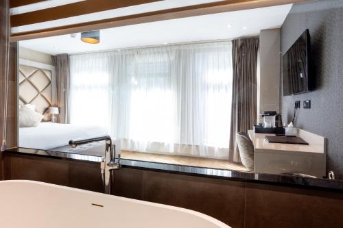 a bathroom with a sink and a large mirror at Dream Hotel Amsterdam in Amsterdam