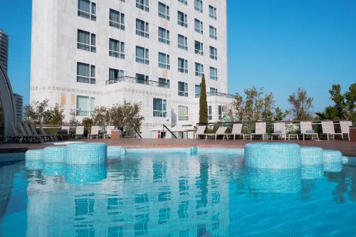 a swimming pool in front of a building at Sercotel Sorolla Palace in Valencia