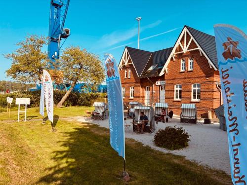 a house with a flag in front of it at Kanal-Haus "Das Gästehaus direkt am NOK" in Osterrönfeld