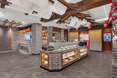 a restaurant kitchen with a counter with food at Xingshengjiu Courtyard Hotel Pingyao in Pingyao