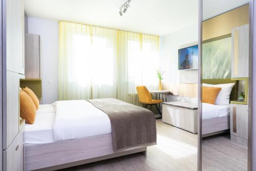 a bedroom with a bed and a desk and a table at HOTEL Am Spichernplatz in Düsseldorf