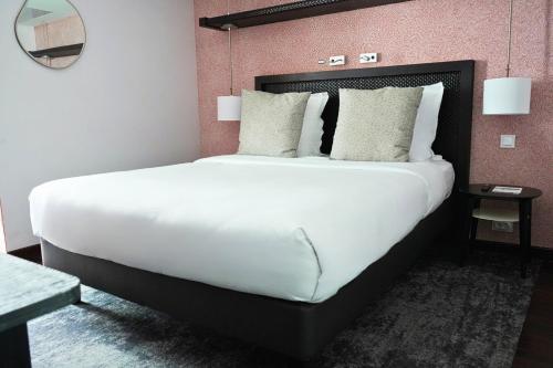 a large white bed in a hotel room at Hôtel Elysées Régencia in Paris