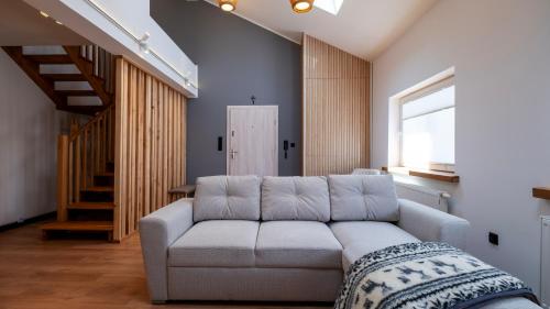salon z kanapą i schodami w obiekcie Apartamenty Sun & Snow Ustroń Przy Rynku w Ustroniu