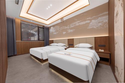 a room with three beds and a skylight at Xingshengjiu Courtyard Hotel Pingyao in Pingyao