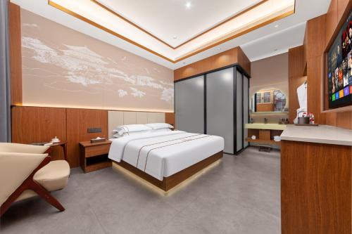 a bedroom with a bed and a desk and a television at Xingshengjiu Courtyard Hotel Pingyao in Pingyao