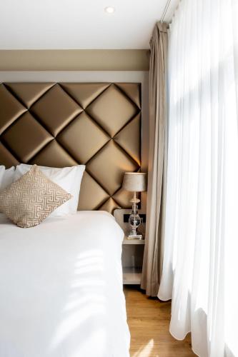 a bedroom with a large white bed and a window at Dream Hotel Amsterdam in Amsterdam