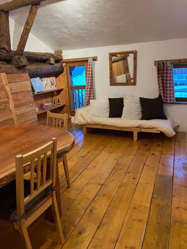 a living room with two beds and a wooden floor at La Cerveyrette in Cervières