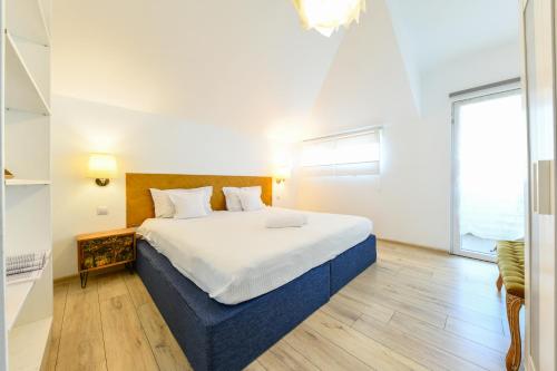 a bedroom with a large bed and a large window at Cluj Napoca Apartments in Cluj-Napoca