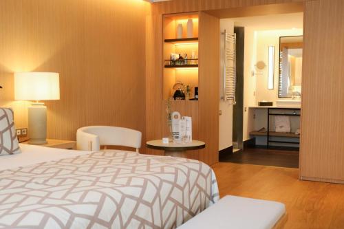 a bedroom with a bed and a living room at Hospes Palau de La Mar, Valencia, a Member of Design Hotels in Valencia