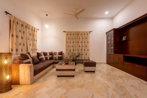 Una sala de estar con un sofá y un televisor. en Meenakshi residency, en Alāndurai