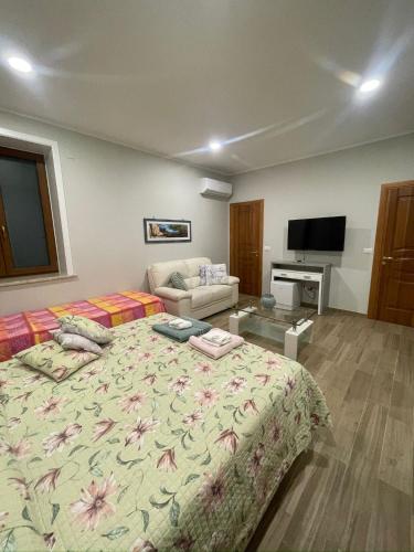 a bedroom with a large bed and a couch at VILLA IZZO B&B in Bagnoli