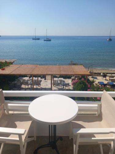 a white table and chairs on a balcony overlooking the ocean at Studios Margarita in Platis Yialos Sifnos