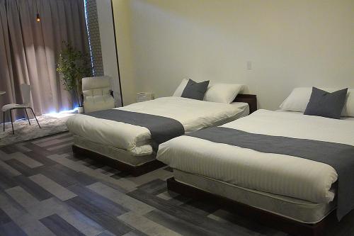 a hotel room with two beds and a chair at Kototoki-Ren-201 Superior Twin room in Hiroshima