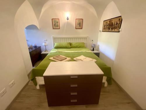 a bedroom with a green bed in a small room at Il Viaggiatore House in Calice Ligure