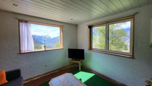 a room with two windows and a television in it at Panoramaplatz in Ried-Brig