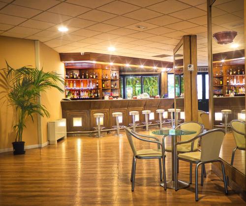 a restaurant with a table and chairs and a bar at San Paolo Palace Hotel in Palermo