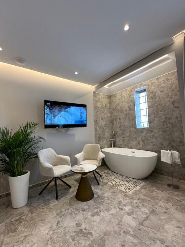 a bathroom with a tub and a tv on the wall at Jericho rooms in Sarandë