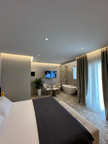 a bedroom with a large bed and a bath tub at Jericho rooms in Sarandë