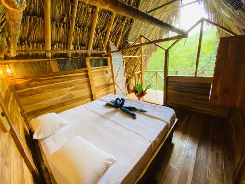 a bedroom with a bed with a bow on it at Finca Carpe Diem Ecolodge in Minca