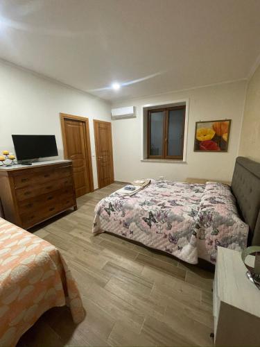 a bedroom with a bed and a desk with a television at VILLA IZZO B&B in Bagnoli
