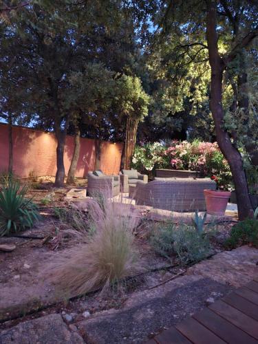 a garden with a bench and trees and plants at Logement indépendant avec Jacuzi pour 4ou 5 personnes, 2 chambres in Aureille