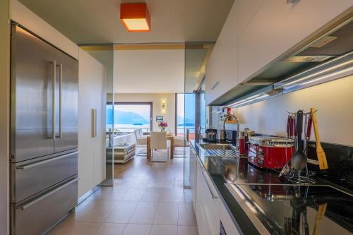 a kitchen with stainless steel appliances and a living room at Casa Bella Vista in Laveno