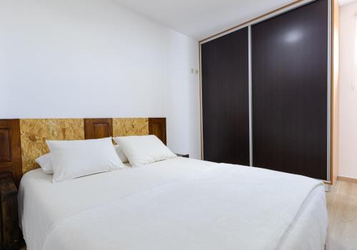 ein Schlafzimmer mit einem weißen Bett und einem großen Fenster in der Unterkunft House Dinavast Bungalow in São João da Pesqueira