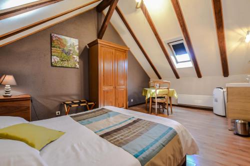 a bedroom with a bed and a table in it at Gîte Oncle Yerry Ostheim in Ostheim