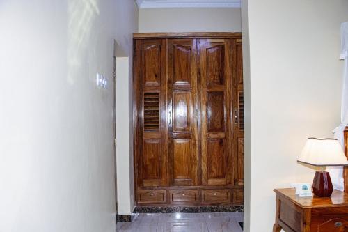 a large wooden cabinet in a room with a lamp at Sunny Palms Beach Bungalows in Uroa