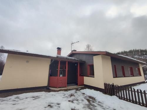 una casa con una puerta roja en la nieve en Artjarvi Center Art Villa vacation house, en Artjärvi