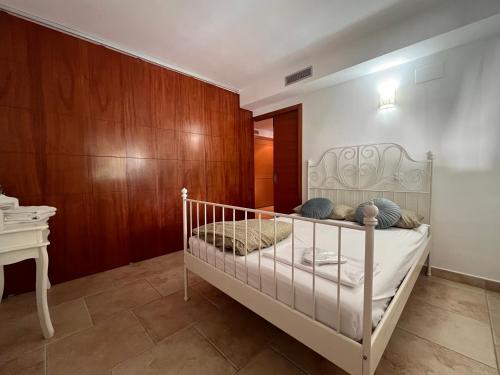 a bedroom with a white bed and a wooden wall at Villa Montgó in L'Escala