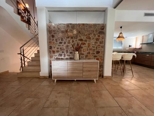 a living room with a staircase and a stone wall at Villa Montgó in L'Escala
