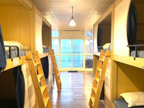 基隆市にある中華郵輪文旅-基隆海景の複数の二段ベッドと窓が備わるドミトリールームです。