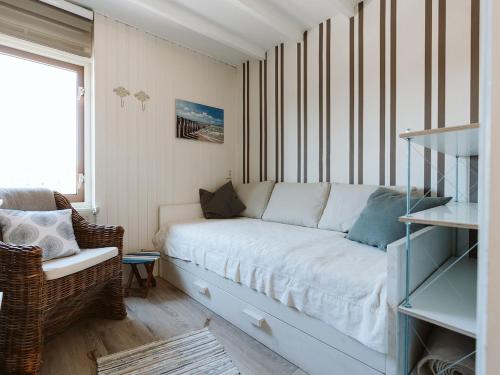 a living room with a white couch and a chair at Vakantiehuis Zuid-Holland nabij zandstrand VP073 in Ouddorp