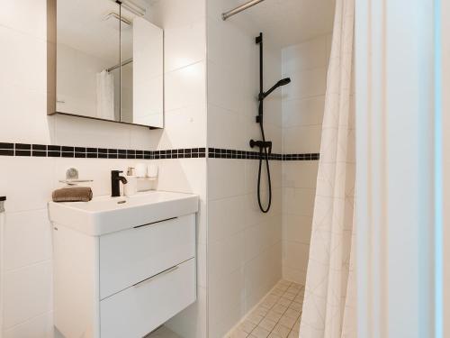 a white bathroom with a sink and a shower at Vakantiehuis Zuid-Holland nabij zandstrand VP073 in Ouddorp