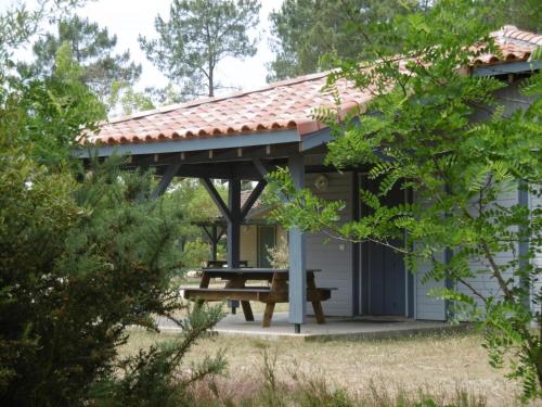 a pavilion with a picnic table in a garden at Les bruyeres in Brocas