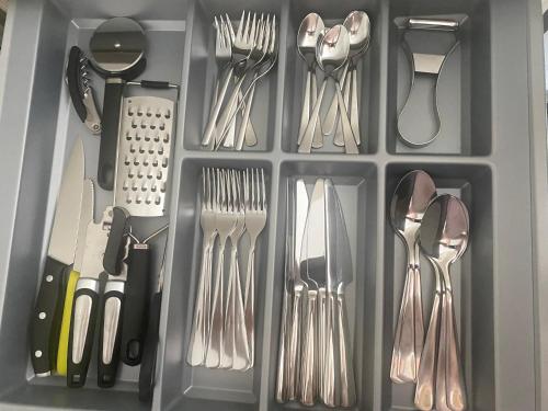 a gray drawer filled with utensils and spatulas at Gemütliche Ferienwohnung mit Sonnenterrasse in Schlitz