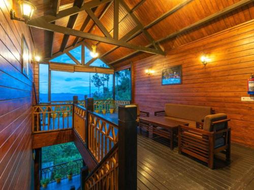a cabin with a table and a bench on a balcony at The Hosteller Kasar Devi in Almora