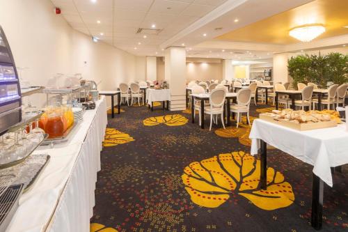 a banquet hall with tables and chairs with food on them at Hôtel Paradis in Lourdes