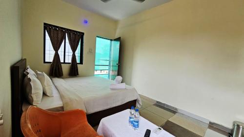 a bedroom with a bed and a table and a chair at Seafront Homes Stay in Daman