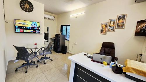 a room with a desk and a table with chairs at Seafront Homes Stay in Daman