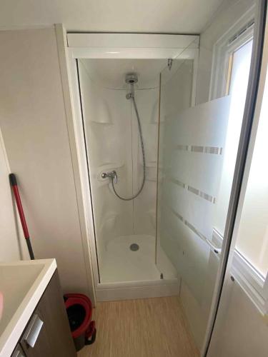 a shower with a glass door in a bathroom at Mobile home à Mimizan in Mimizan