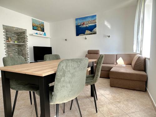 Una sala de estar con una mesa y sillas y un sofá. en Blue Coast Ivo, en Piran