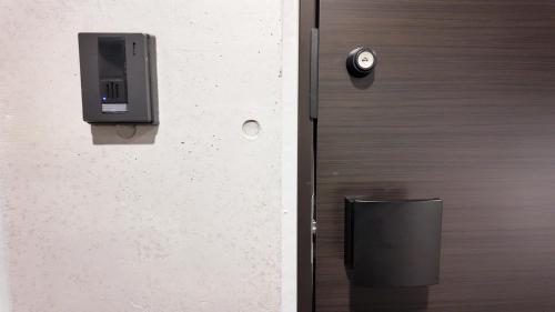 a close up of a door with a security camera at 9Stay文京大塚 in Tokyo