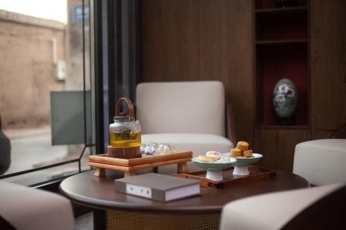 a living room with a table with food on it at Xingshengjiu Courtyard Hotel Pingyao in Pingyao