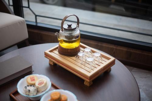 a tea kettle on a tray on a table with food at Xingshengjiu Courtyard Hotel Pingyao in Pingyao