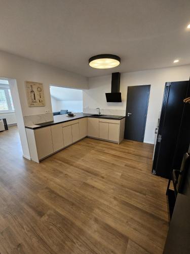 an empty room with a large kitchen with a hard wood floor at Penzion Royal in Trenčín