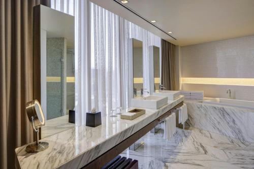 a bathroom with two sinks and a tub and mirrors at The Westin Santa Fe, Mexico City in Mexico City